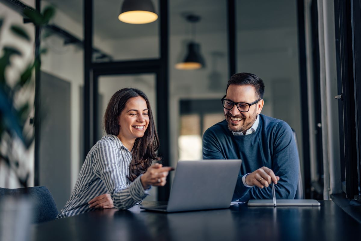 Smiling people, in the meeting room, using a laptop